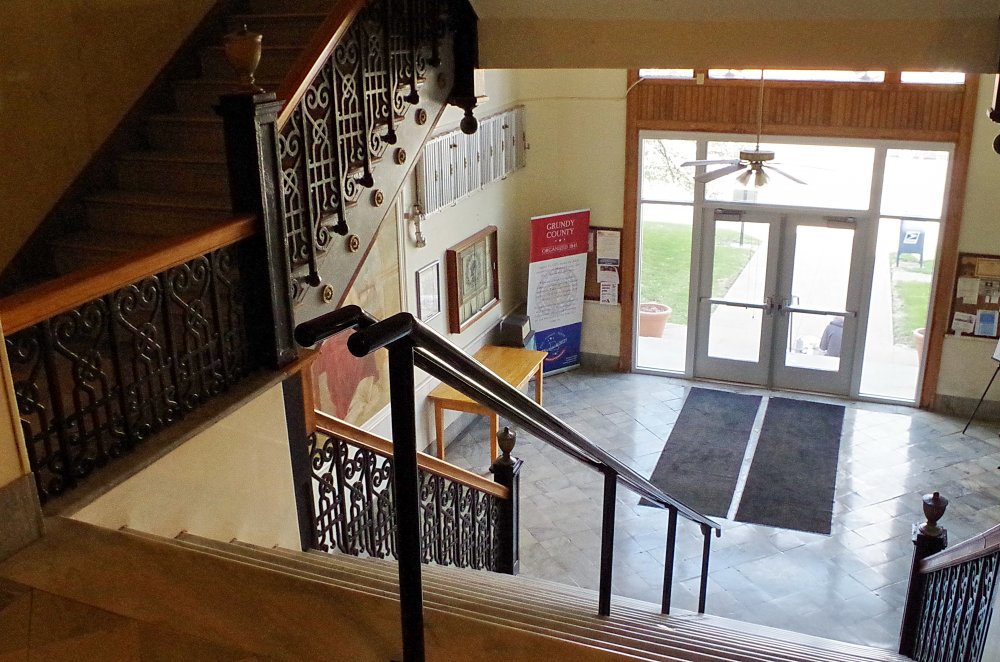 picture showing stairs to 1st floor landing and main street doors
